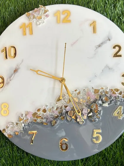 A unique clock design combining a grey and white base with delicate pink and gold crystal accents.