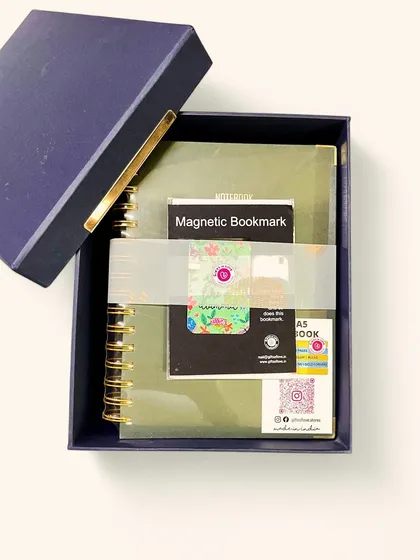 A closer look at the Crisp Sequoia Notebook, paired with a magnetic bookmark. The deep olive green cover and gold accents give it a feeling of quiet luxury.