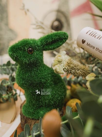 A detailed shot of a moss-covered rabbit figurine, a small but charming element of the woodland theme.