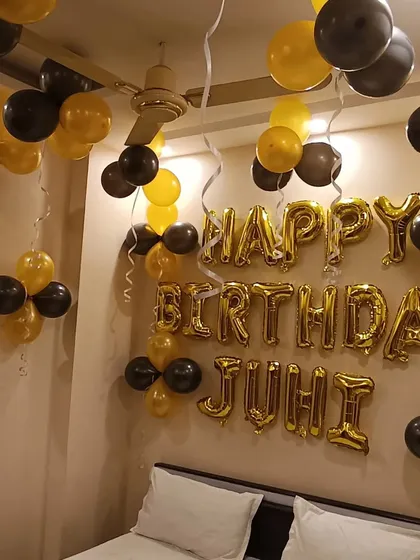 A full view of the black and gold bedroom decoration for Juhi's birthday. It's a simple, classic, and elegant way to surprise someone.
