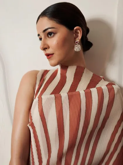 The striped pattern of her attire creates a beautiful contrast with the intricate floral details of the micromosaic earrings worn by Ananya Panday.