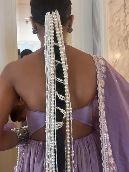 Working with influencers like Nancy Tyagi means creating unique, trendsetting looks. This dramatic pearl-draped braid is a showcase of creativity, and I teach the methods for securely attaching heavy accessories to create a high-fashion statement.