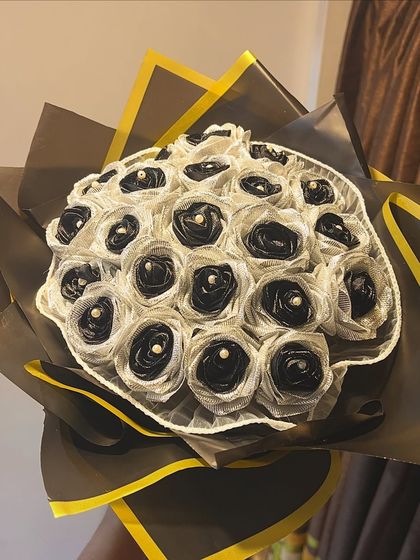 A clean, beautiful shot of the 21 black and silver satin rose bouquet. Each rose has a delicate pearl at its center, adding a touch of classic elegance.