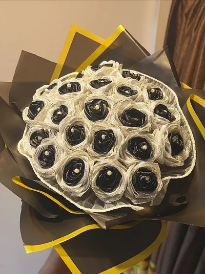 A clean, beautiful shot of the 21 black and silver satin rose bouquet. Each rose has a delicate pearl at its center, adding a touch of classic elegance.