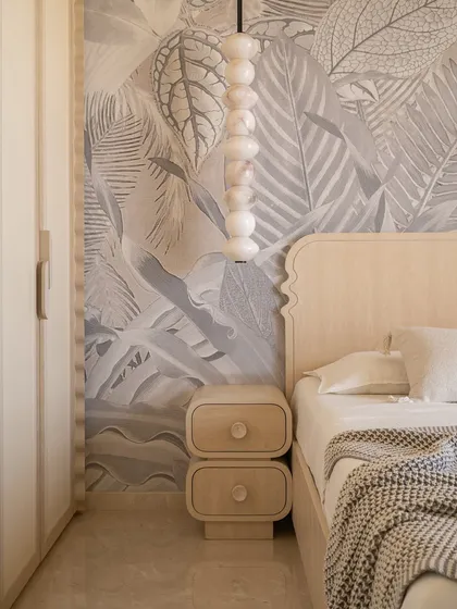 The guest bedroom in our 'Soft Serve' project blends minimalism with organic touches. A botanical mural serves as a backdrop to the custom curved wooden bed, creating the calming ambiance of a boutique bed and breakfast.