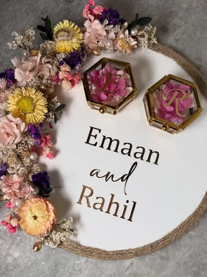 I really enjoy playing with vibrant, preserved flowers to create a piece that pops. This round platter features a crescent of colorful dried flowers, a jute rope border for a rustic touch, and two hexagonal glass boxes to hold the rings.