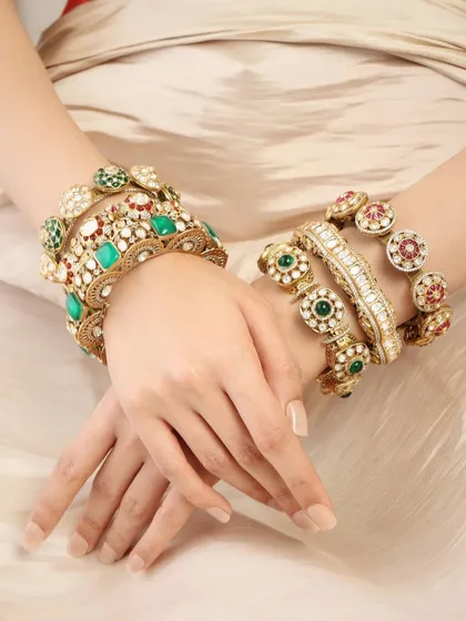 A beautiful display of stacked bangles in shades of emerald and ruby, as seen on Pashmina Roshan, perfect for adding color to any festive outfit.