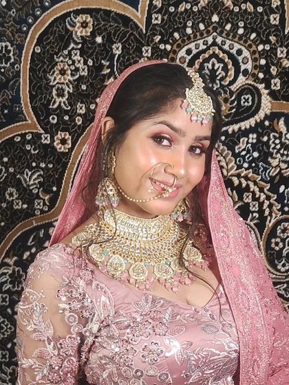 A smiling model in the pink lehenga, showing how my outfits and jewellery can help create happy, beautiful clients.