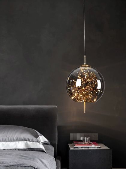 Here is one of my popular 'firefly' globe pendants installed as a bedside light. The cluster of tiny LED lights within the glass sphere creates a warm, magical glow, perfect for adding a touch of whimsy and elegance to a bedroom.