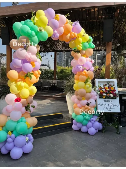 A colorful balloon archway at the entrance of the 'Baby in Bloom' baby shower, creating a vibrant welcome for guests.