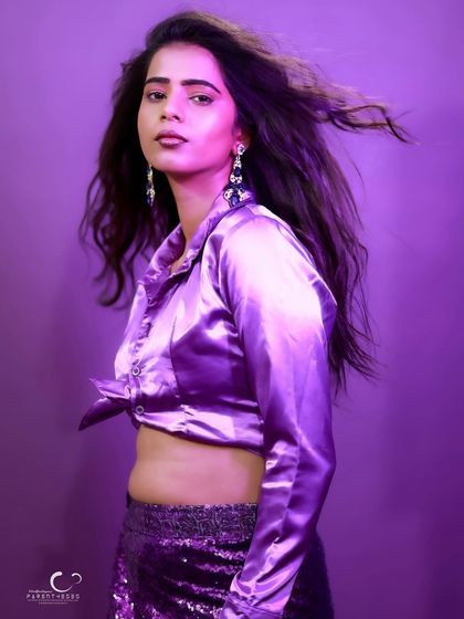 A chic and modern portrait in a purple satin outfit. The wind-blown hair adds a touch of effortless glamour.