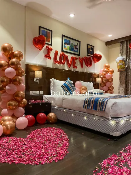 This shot captures the romantic ambiance created by combining "I Love You" foil balloons with balloon columns and petal arrangements.