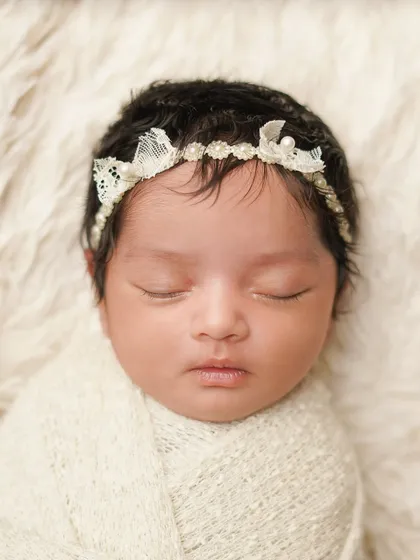 Another close-up of the newborn's face, showing the peacefulness of her sleep. The simple, neutral tones keep the focus entirely on the baby.
