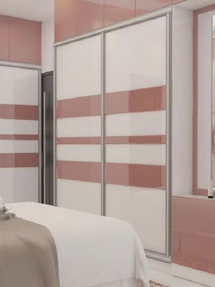 This bedroom features sliding wardrobe doors with a pink and white striped pattern, adding a touch of modern elegance. The design also includes a small vanity nook and open shelving for decor.