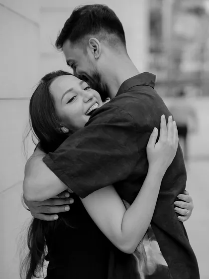 A joyful, heartfelt hug captured in timeless black and white. This image shows how I focus on raw emotion, creating powerful and classic couple portraits against a simple urban backdrop.