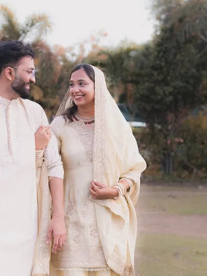 A gentle walk together after their ceremony. This candid photo of a Muslim couple in coordinated cream outfits shows the simple, happy beginning of their new life.