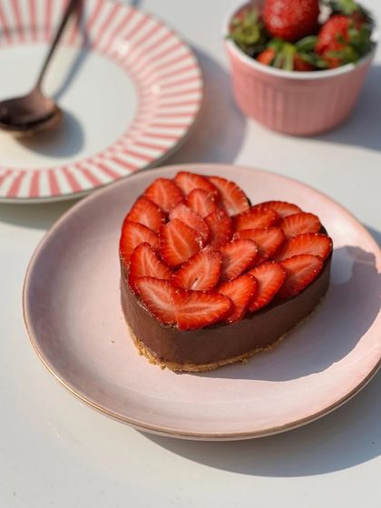 My heart-shaped mini Belgian chocolate mousse cake, topped with fresh, sliced strawberries. A perfect romantic dessert for two.
