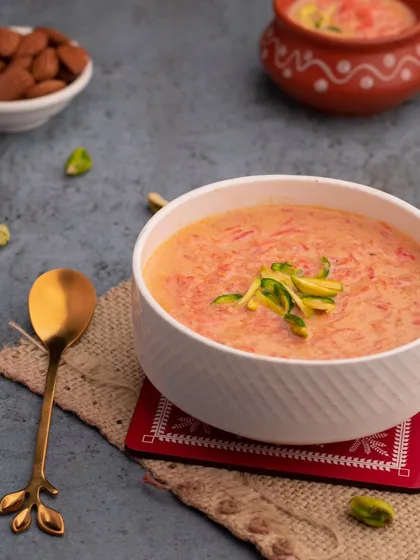 A comforting bowl of Gajar Kheer (carrot pudding). The simple styling with a sprinkle of pistachios makes it look homemade and delicious.