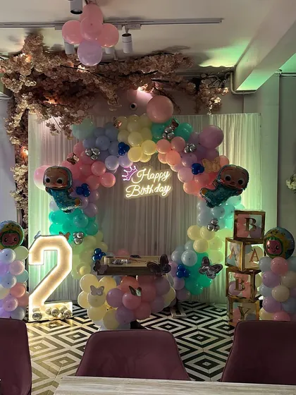The complete Cocomelon-themed setup with a light-up number '2' and balloon pillars.