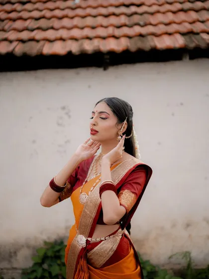 A serene portrait of a model in a traditional saree. Her eyes are closed, and the focus is on the beautiful details of her makeup and the texture of the fabric.