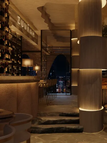 The transition from the bar to the main dining area is marked by hand-cut stone steps, reinforcing the cave-like narrative. The design creates a journey through different levels and textures.