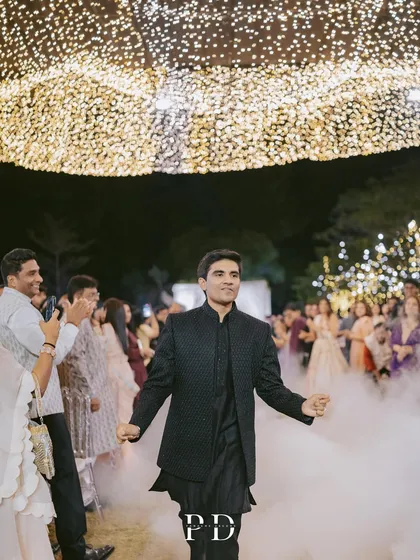 The groom's grand entrance with a smoke machine creating a dramatic, cloudy effect under the starry fairy lights. It's all about creating a high-impact, memorable experience.