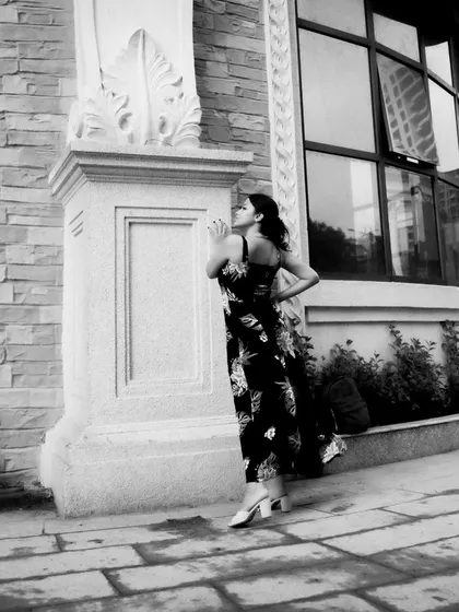 A black and white series exploring different poses against architectural elements. These shots focus on form, light, and the interaction between the subject and her environment.