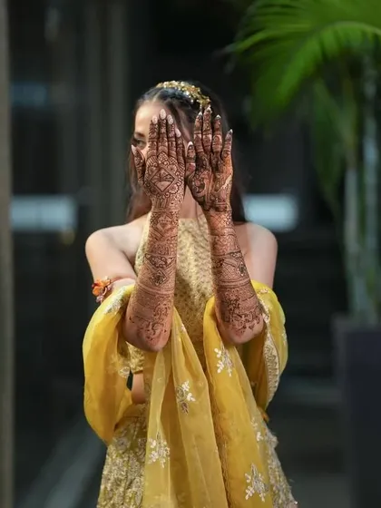 Another classic "peek-a-boo" pose, with the bride's full-arm mehendi creating a beautiful frame for her face.