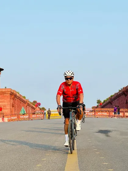 A rider in a red floral jersey, captured mid-ride.