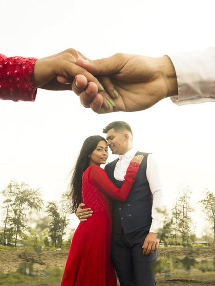 A creative composition symbolizing unity and connection. The couple's hands are held together above a portrait of them in a natural landscape, creating a unique and artistic image about their bond.