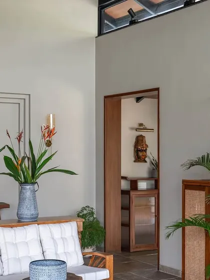 A view from the living room of Grove House, looking through a doorway into another part of the home. The design uses natural materials and an open layout to create a sense of flow and connection throughout this Alibaug weekend retreat.