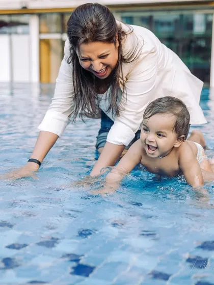 A baby's first splash in the pool during his birthday celebration. This candid shot captures the pure joy and excitement of a new experience, making for a truly memorable photo.