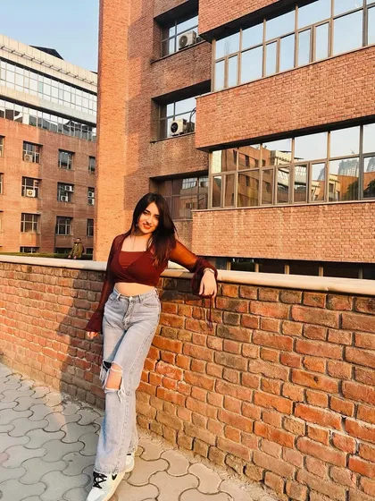 A golden hour shot in a sheer brown top and ripped jeans. This outfit is all about that relaxed, cool-girl vibe.