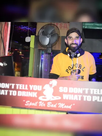 A fun photo behind a sign that says "We don't tell you what to drink, so don't tell us what to play." Trust me to curate the vibe.