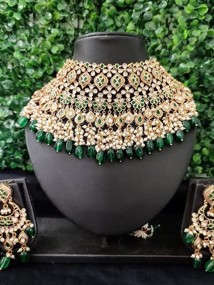 A beautiful green and white kundan choker set for rent. The design features delicate floral motifs and pearl drops, paired with matching earrings.
