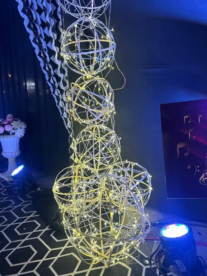 A close-up of the illuminated wire sphere props used in the Sangeet passage decor.