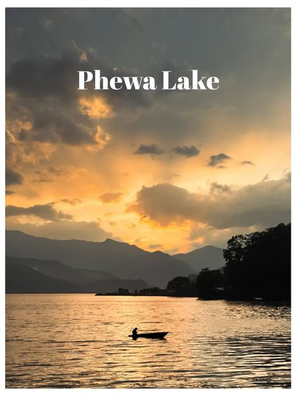 A lone boatman on Phewa Lake at sunset, the dramatic sky reflecting on the water. A perfect moment of tranquility.