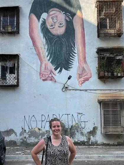An upside-down portrait of a girl hangs over a "No Parking" sign. This thought-provoking piece in the Mahim Art District is a statement on the need for public spaces for children to play.