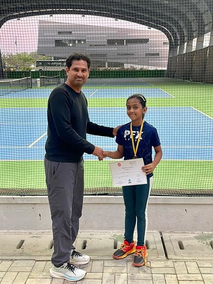 A coach congratulates a young player on her performance in a UTR event. We focus on sportsmanship and personal growth alongside winning.