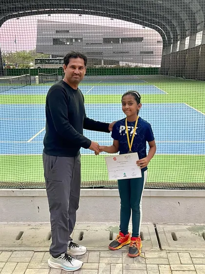 A coach congratulates a young player on her performance in a UTR event. We focus on sportsmanship and personal growth alongside winning.