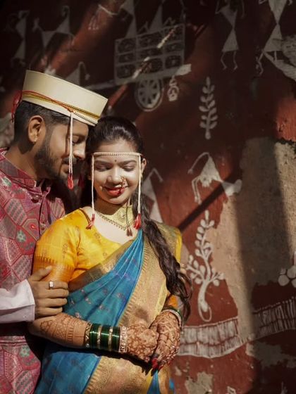 A creative portrait against a wall with traditional Warli art, blending culture with romance.