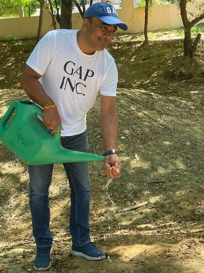 A volunteer from Gap Inc. waters a sapling, contributing to the health of Aravali Creek and protecting natural resources for future generations.