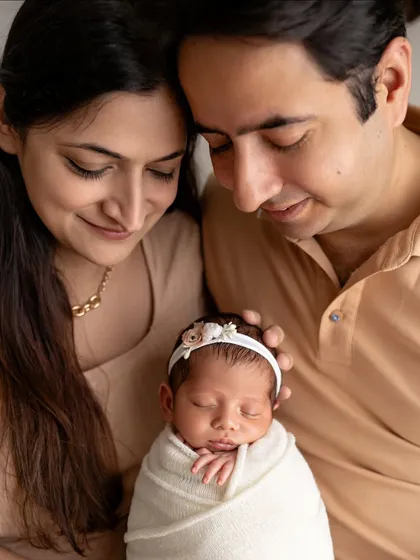 A close-up of new parents, their faces full of love as they look at their newborn.