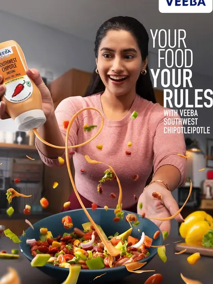 The final ad layout for Veeba's Southwest Chipotle sauce, showing the dynamic splash and flying salad ingredients. The text overlay completes the story, creating a vibrant and persuasive visual for the campaign.