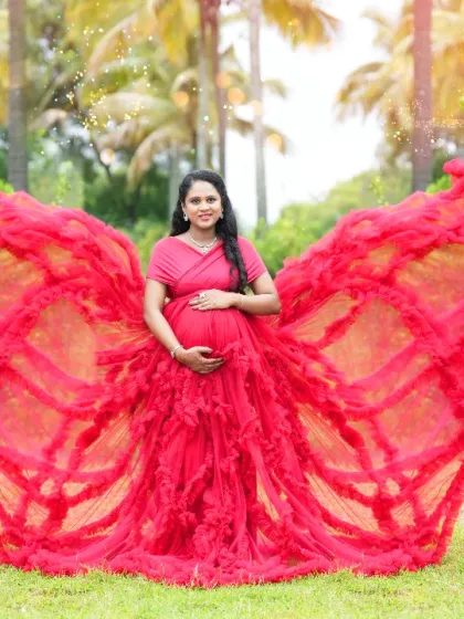 A stunning butterfly pose with a red ruffled gown, showcasing the dress's dramatic design in our outdoor location.