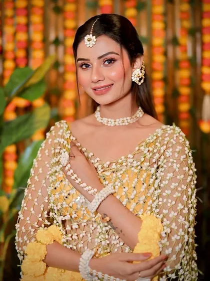 A beautiful shot capturing the intricate details of the floral jewellery and the fresh, dewy makeup.