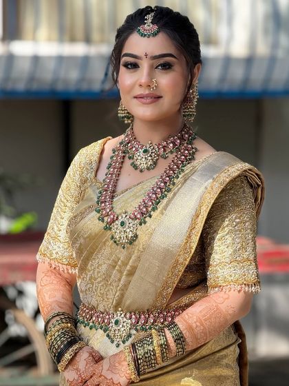 A smiling portrait of the bride, looking radiant and ready for her big day. The makeup is fresh and enhances her joyful expression.