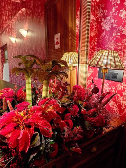A stunning floral display in shades of red set against a red patterned wall, creating a bold, monochromatic look for the restaurant launch.