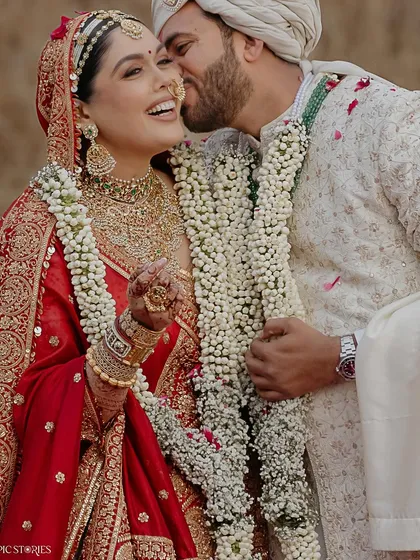 A candid moment of affection between Jigar and Amruta. The groom's playful kiss and the bride's joyful laugh perfectly capture the fun and love that defined their wedding day.