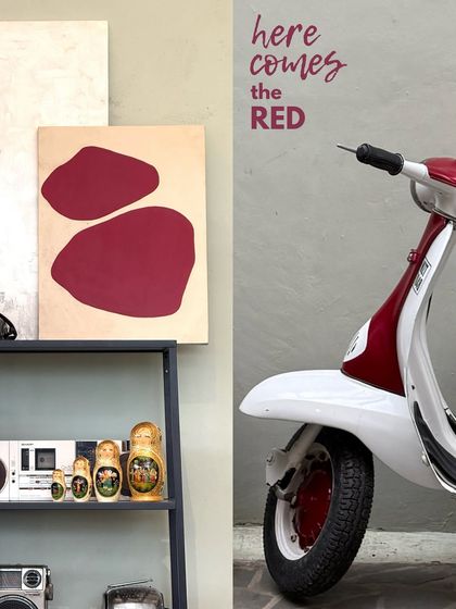 Here comes the red. A pop of color from a red scooter parked outside a cafe, coordinated with abstract art inside.